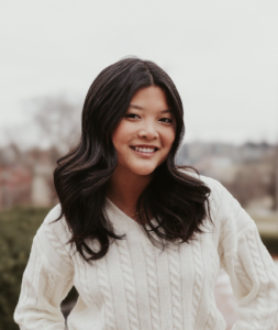 A woman in a white sweater, smiling. 